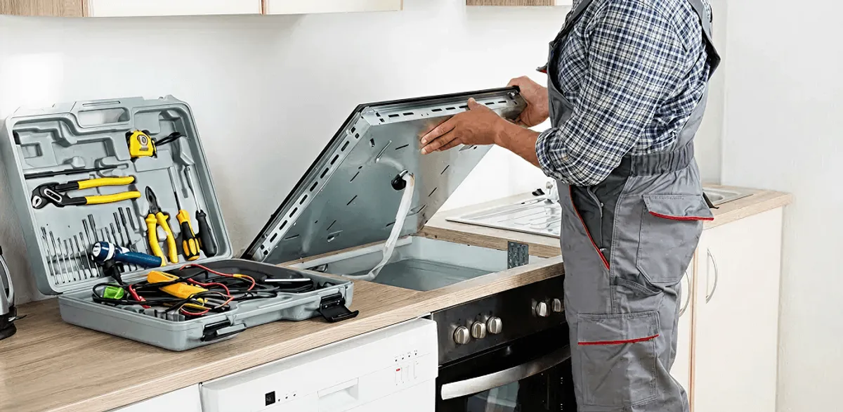 Handyman repairing a cooktop and checking wiring connections in South Bend, IN