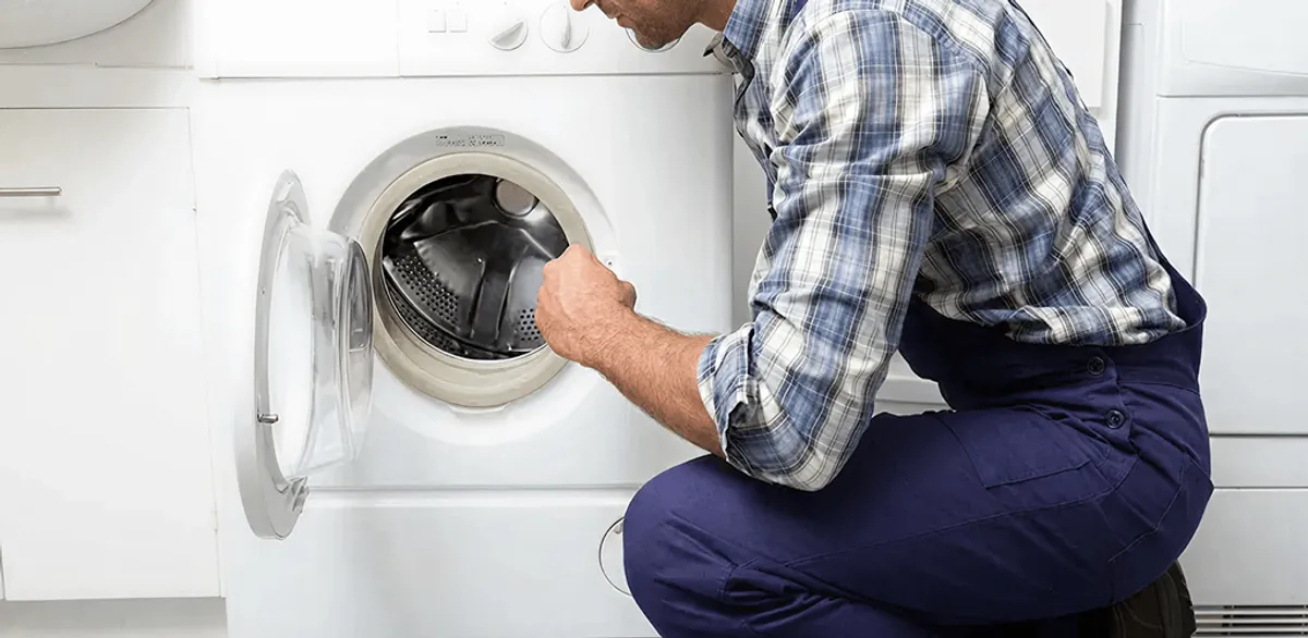 Handyman inspecting a dryer drum and internal parts for repair in South Bend, IN