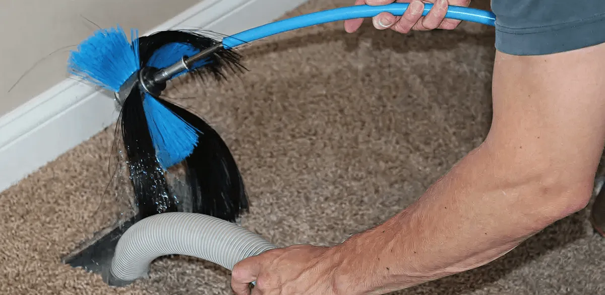 Dryer vent cleaning technician brushing lint from a vent line in South Bend, IN